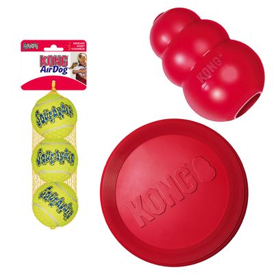 Een set van KONG hondenspeelgoed, inclusief drie gele tennisballen, een rode frisbee en een KONG kauwspeeltje.